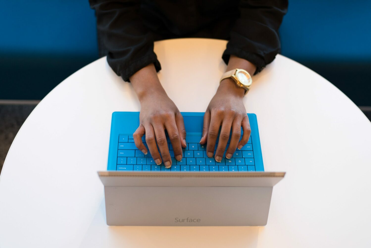 Person's hands hovering over an open laptop